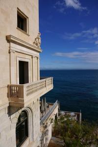 卡斯卡塔拉Hospes Maricel y Spa, Palma de Mallorca, a Member of Design Hotels的带阳台的建筑,可俯瞰大海