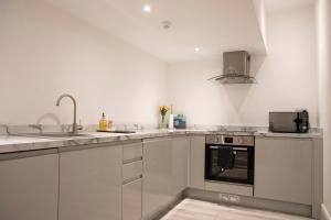 赫尔#5 Grimston St Apartment near Hull New Theatre and Connexin Live的白色的厨房设有水槽和炉灶。