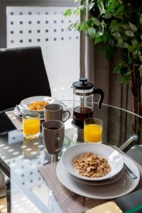 红山Castle Haven Apartment, Redhill的一张桌子,上面放着两盘食物和橙汁