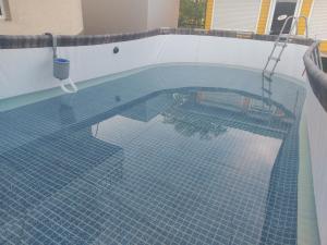 扎托卡Отель Маленький Рай的游泳池铺有蓝色瓷砖地板。