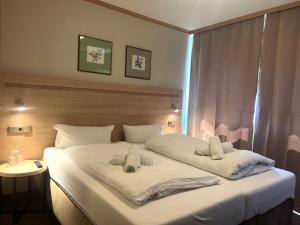 阿沙芬堡桑德豪斯阿尔特斯酒店的卧室配有带毛巾的大型白色床