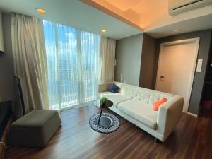 吉隆坡Verve 2Bedroom 2to6pax Kuala Lumpur near Midvalley MegaMall的客厅配有白色沙发和大窗户