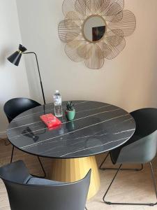 蒙特卡罗Studio im Herzen von Monte Carlo的一张带椅子的黑色桌子和墙上的镜子