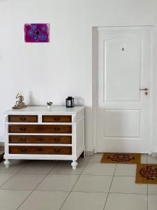 包姚Tanyacsárda Panzió的一间白色的房间,配有梳妆台和白色的门