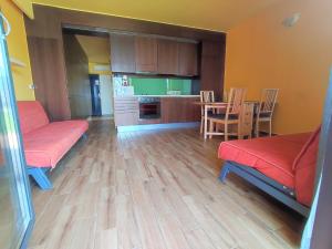 巴拉通雷勒Soleil Apartmanok Balatonlelle的一间带红色沙发的客厅和一间厨房