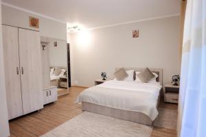 普特纳Casa Isabela的白色的卧室配有白色的床和镜子