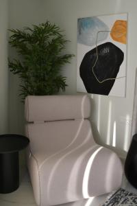 雅典URBAN SUITES ATHENS的白色椅子和室内植物