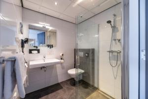 布勒伊尼瑟Hotel Bru的带淋浴、盥洗盆和卫生间的浴室