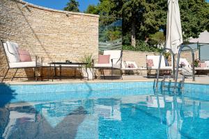 迪斯诺历史帝斯诺酒店的砖墙旁的游泳池,配有椅子和桌子