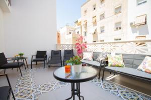 阿利坎特Art Apartments Alicante的阳台配有沙发和桌椅。