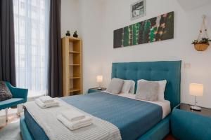 波尔图Ndussole Guest House的一间卧室配有蓝色的床和椅子