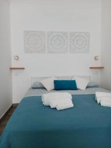 托里德欧索Camere A Oriente II的一张蓝色的床,上面有三个枕头