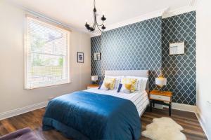利明顿温泉Garden Apartment in Listed Building的一间卧室配有一张带蓝色毯子的床