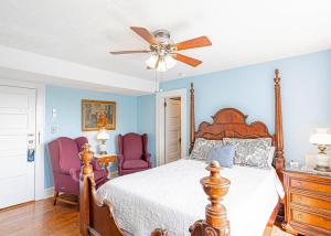 亨德森维尔Echo Mountain Inn的一间卧室配有一张床和两张紫色椅子