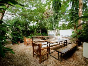 达累斯萨拉姆慢豹旅舍的一组野餐桌和长凳在花园里