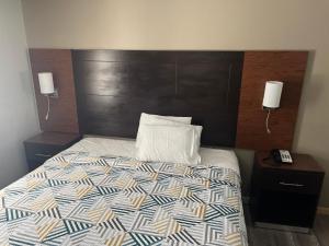 塔尔萨Motel 6 Tulsa, OK Airport的一间卧室配有一张带木制床头板的床