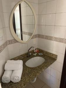 弗洛里亚诺波利斯Pousada Bangalôs Da Mole - Florianópolis的浴室配有盥洗盆、镜子和毛巾