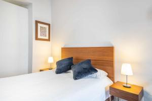马德里Chueca Gran Via Recoletos Libertad 24 8的一间卧室配有白色的床和2个蓝色枕头