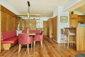 巴德哥依斯恩Appartementhaus Dachsteinblick mit Indoorpool und Sauna的客厅配有红色的沙发和桌子
