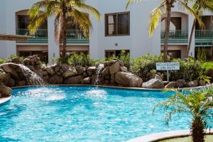 棕榈滩The Mill Resort and Suites的度假村内带瀑布的游泳池