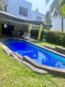 圣何塞港Casa Villas del Pacifico Puerto San José的房子前面的蓝色游泳池