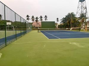 圣何塞港Casa Villas del Pacifico Puerto San José的一个带网球网和棕榈树的网球场