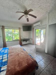 圣何塞港Casa Villas del Pacifico Puerto San José的一间卧室配有一张床和吊扇