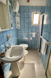 圣伊西多罗White House Salento的蓝色瓷砖浴室设有水槽和卫生间