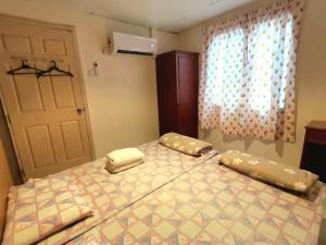 邦咯Pangkor Coral Bay Homestay 315的一间卧室配有带两个枕头的床和窗户