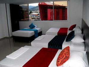 卡利AW Hotel Sport的带三张床和窗户的客房