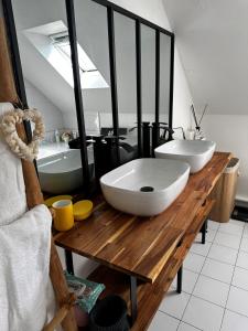 坎佩尔LES TEMPS HEUREUX exclusivement Familles的浴室设有木桌上的两个白色水槽