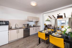 梅杜林Apartman Bijeca - Medulin的厨房以及带桌子和黄色椅子的用餐室。