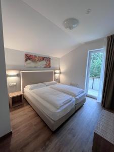 沃尔特湖畔韦尔登Apartments Roemerschlucht的卧室设有一张白色大床和一扇窗户。