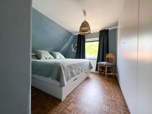 比苏姆"Ohuus" Ferienhaus mit Garten的一间卧室设有一张床和蓝色的墙壁