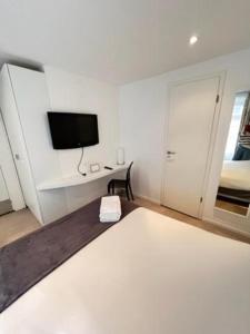 斯特拉斯堡Residence OLit Cathédrale的白色的客房配有床和电视。