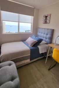 安托法加斯塔Departamento en Antofagasta 2D+1B FULL的一间卧室配有一张床、一张书桌和一个窗户。