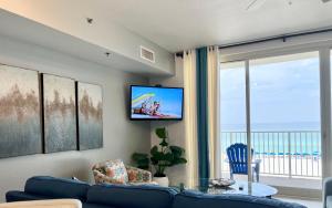 巴拿马城海滩Shores of Panama Condo With Same Level Parking的客厅配有蓝色的沙发和电视