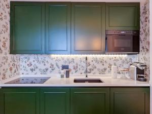 瓦拉泽Il Caruggio Flat的厨房配有绿色橱柜和水槽