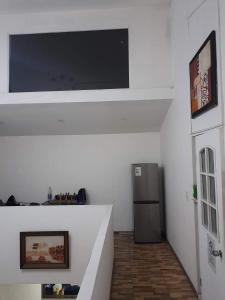 圣地亚哥Hostal Pura Vida的一间带电视和冰箱的客厅