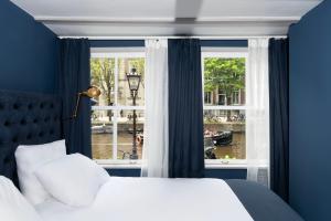 阿姆斯特丹Stanley Collection Hotel Hegra Amsterdam的一间卧室设有一张床和一个大窗户