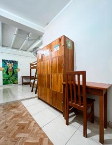 塔拉波托El Mural Backpackers的客房设有木桌和木柜。