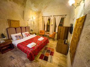 于尔居普Heritage Cave Suites的一间卧室配有一张带红色毯子的大床