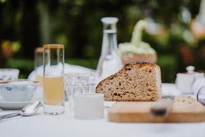 梅拉诺奥特曼古特套房及早餐酒店的一张桌子,上面放着一面包和一瓶葡萄酒