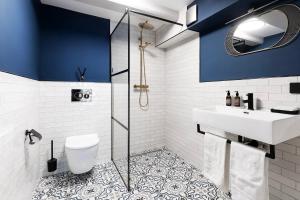 阿姆斯特丹Stanley Collection Hotel Hegra Amsterdam的浴室设有蓝色的墙壁、水槽和卫生间。