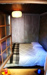 贝尔蒙特Cantinho Santiago的一个小房间的一个床位,设有窗户
