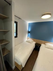 勒蒙多尔L'Ecrin d'Edern 4pers Mont Dore的蓝色墙壁客房的两张床