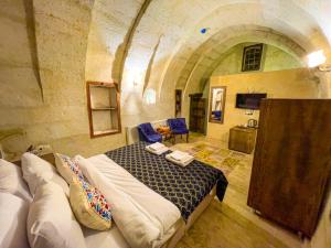 于尔居普Heritage Cave Suites的石头间内一间卧室,配有一张床
