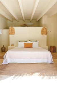 圣埃乌拉利亚坎多摩农场酒店的一间卧室配有一张白色床和两盏吊灯