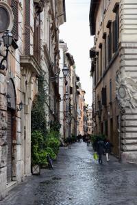 罗马coronari apartments 2的一条小巷,人们沿着街道走在建筑之间