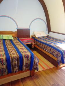 Isla de la LunaHostal Qhana Pacha的两张睡床彼此相邻,位于一个房间里